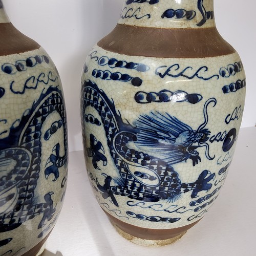 109 - A pair of large Chinese blue and white baluster vases decorated with dragons chasing the flaming pea... 