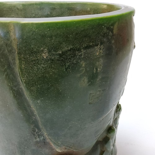 113 - A Chinese spinach green jade brushpot of oval form, finely carved with a scene of a sage and at... 