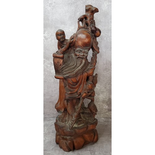 87 - A large Chinese hardwood carving of the immortal Shoulao with a boy, well carved and pierced through... 