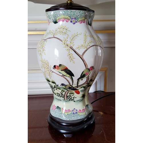 7 - An Oriental hand painted ceramic baluster shaped lamp base decorated with parrots in a naturalistic ... 