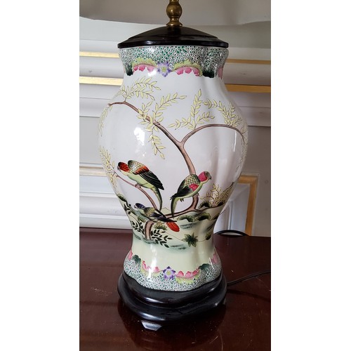 7 - An Oriental hand painted ceramic baluster shaped lamp base decorated with parrots in a naturalistic ... 