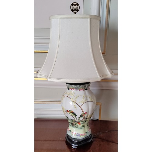 7 - An Oriental hand painted ceramic baluster shaped lamp base decorated with parrots in a naturalistic ... 