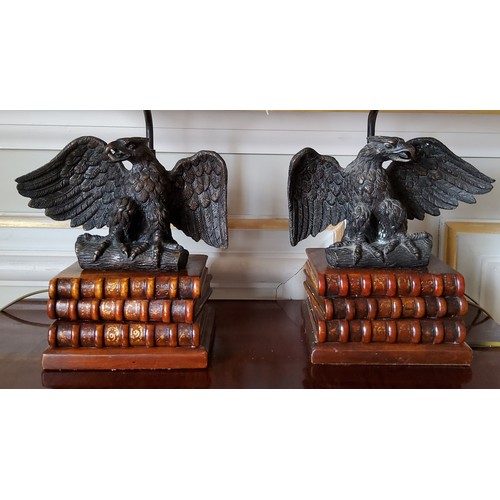 71 - A pair of table lamps, the wooden base in the form three antiquarian books surmounted by a bronze ea... 