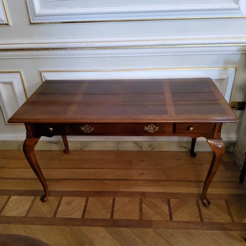 128 - A Regency design mahogany sofa table with a quarter veneered surface, three drawers to frieze, raise... 