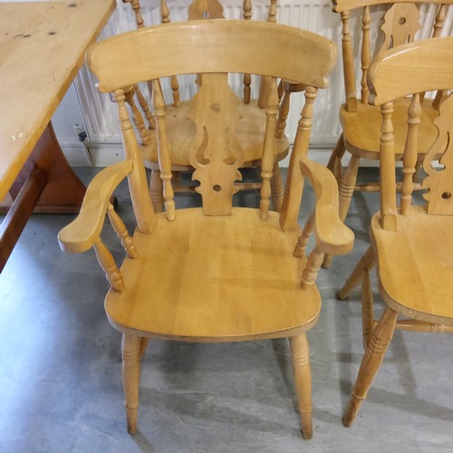 138 - A farmhouse pine kitchen table with four chairs including two carvers, the table support with brande... 