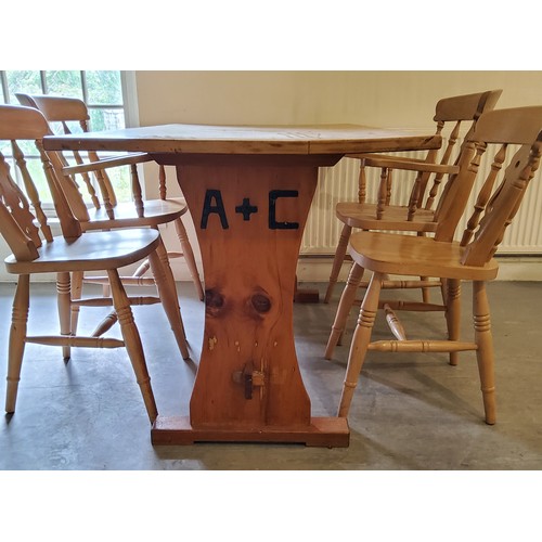 138 - A farmhouse pine kitchen table with four chairs including two carvers, the table support with brande... 