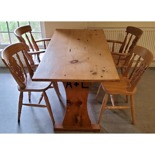 138 - A farmhouse pine kitchen table with four chairs including two carvers, the table support with brande... 