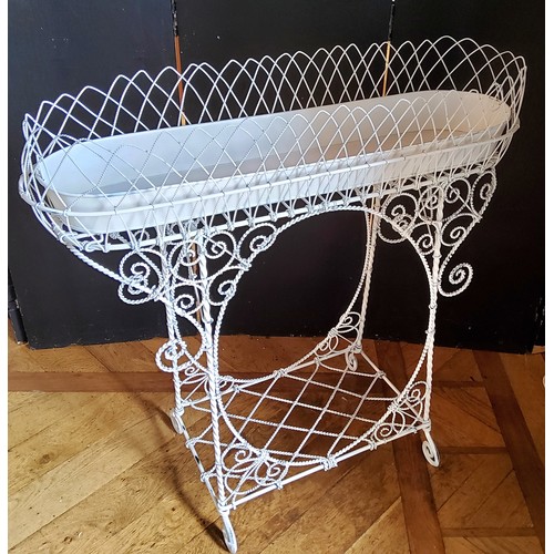 193 - A Victorian style wrought metal elongated oval jardiniere stand, the white painted metal wirework wi... 