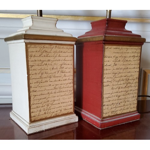 211 - A pair of ceramic table lamps of squat column form, one red and gilt the other cream, the front pane... 