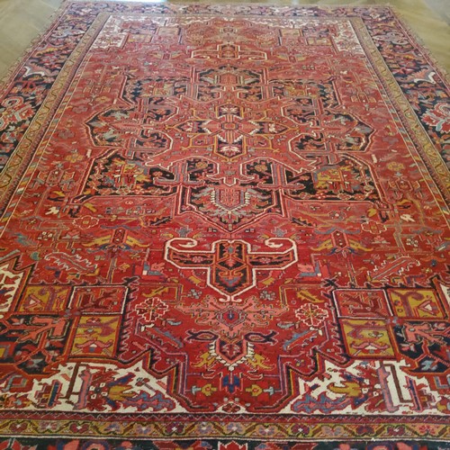 278 - A very large hand knotted Persian Heriz design carpet in rich tones of deep red, white and black