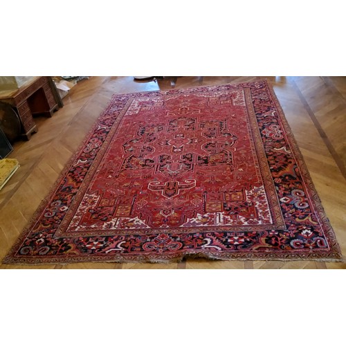 278 - A very large hand knotted Persian Heriz design carpet in rich tones of deep red, white and black