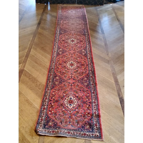 279 - A large hand knotted Hamadan runner with five elephant foot gourds, in tones of red and blue 487cm x... 