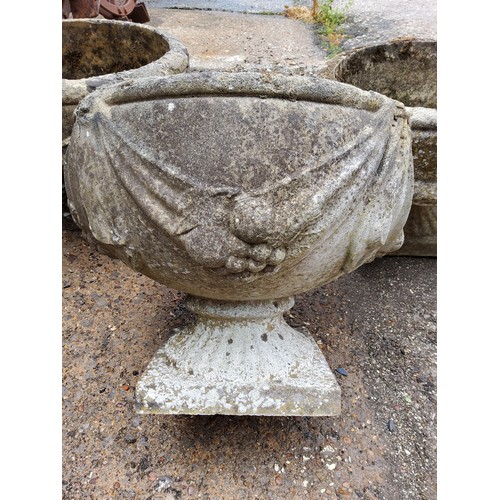 296 - A set of three squat cast concrete planter / urn,  depicting bows and fruits34cm h x 37.5 cm di... 