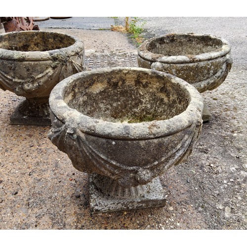 296 - A set of three squat cast concrete planter / urn,  depicting bows and fruits34cm h x 37.5 cm di... 