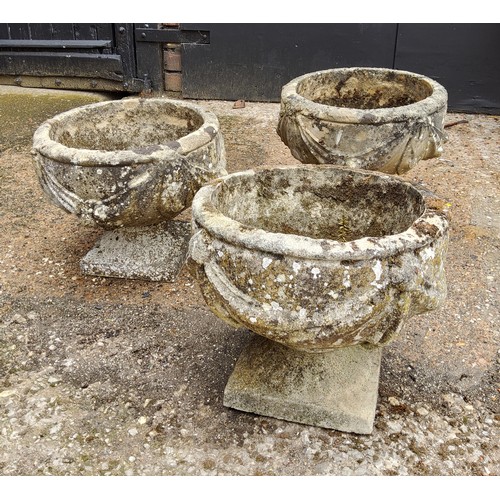 296 - A set of three squat cast concrete planter / urn,  depicting bows and fruits34cm h x 37.5 cm di... 