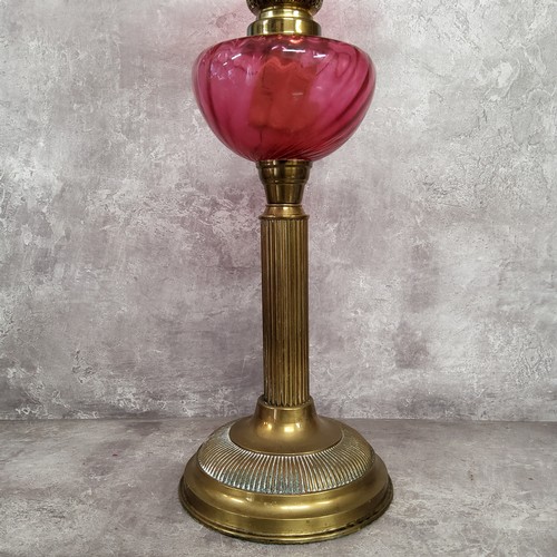 127 - A 19th century French cranberry glass and brass table oil lamp by Gaudard, with wavy ribbed shade ab... 