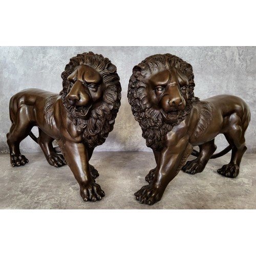 12A - A pair of bronze lions 33cms x 24cms high