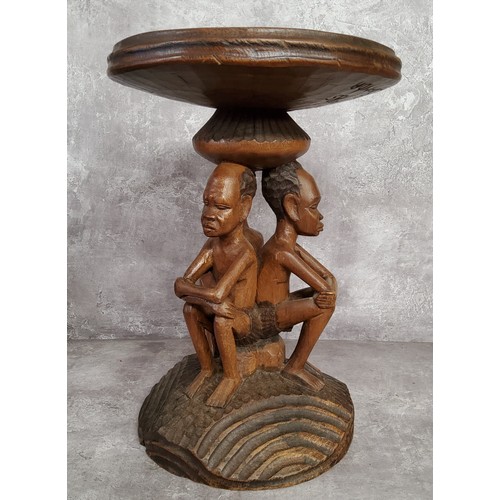 131 - Tribal - a 20th century African elder carving with three seated male carved column, with carved base... 