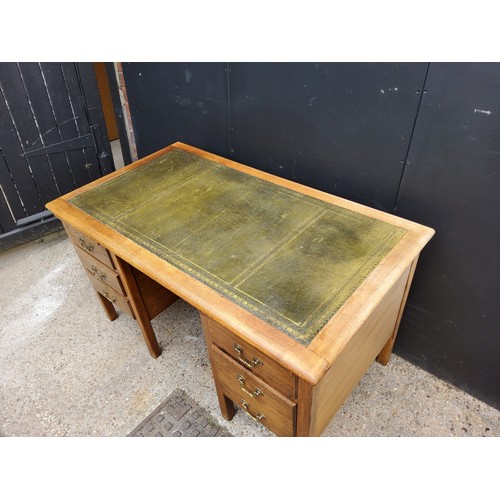 206 - A 1940's oak knee-hole desk with green tooled leather inlaid top, five drawers.H77 x W137 x D76cm... 