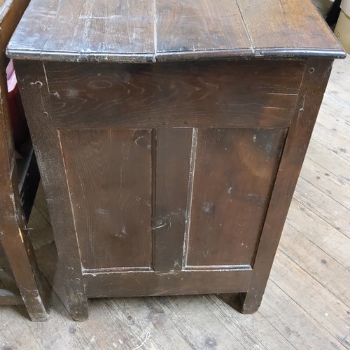 214 - An 18th century vernacular oak Welsh coffer, the cover with early wooden hinges, brass lock above fo... 