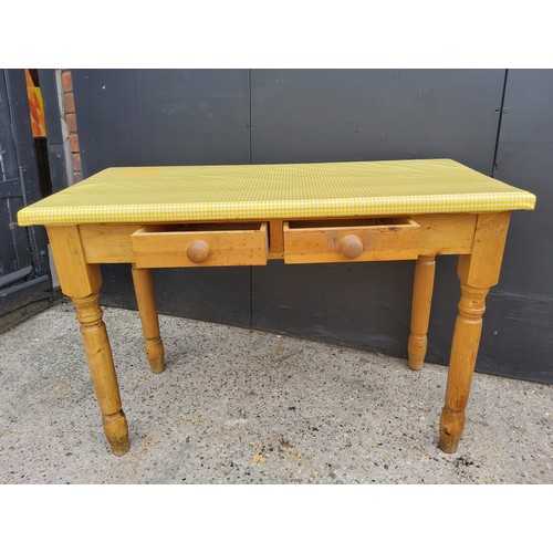 215 - A farmhouse pine side table with two small drawers to frieze, covered in fitted yellow plastic 