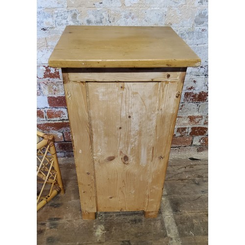 227 - A farmhouse pine bedside cabinet with drawer above  cupboard, raised on bun feet; square bamboo... 