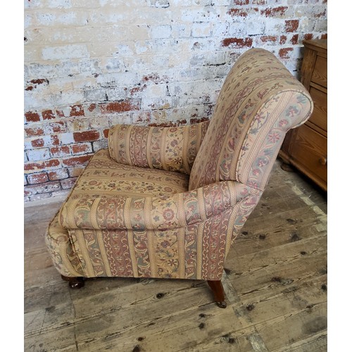 243 - A late Victorian Howard & Sons type armchair re-upholstered in chintz striped fabric, on mahogan... 