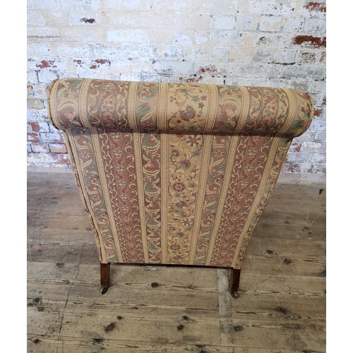 243 - A late Victorian Howard & Sons type armchair re-upholstered in chintz striped fabric, on mahogan... 