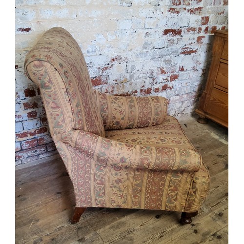 243 - A late Victorian Howard & Sons type armchair re-upholstered in chintz striped fabric, on mahogan... 