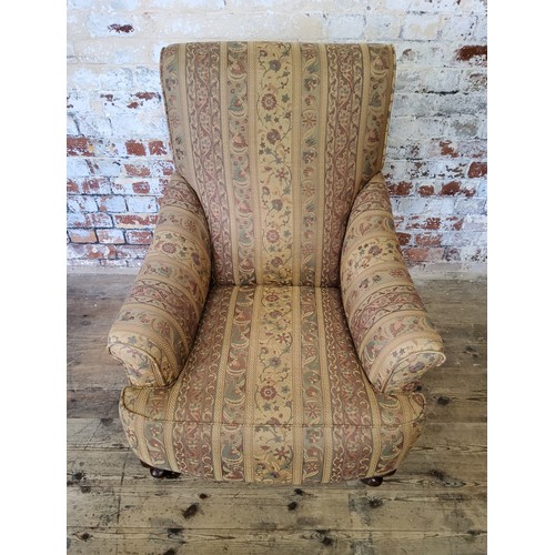 243 - A late Victorian Howard & Sons type armchair re-upholstered in chintz striped fabric, on mahogan... 