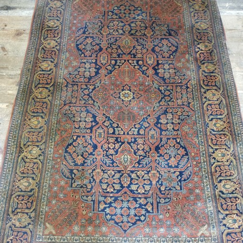 256 - An early 20th century Persian Kashan / Keshan rug in vibrant terracotta, blue and ochre ground with ... 