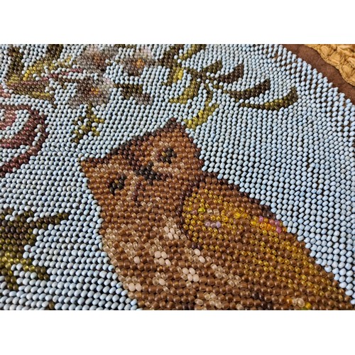 15 - A Victorian beadwork and textile place mat decorated with flowers and an owl c.1860.36cm diameter... 