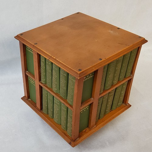 23 - A 1904 revolving miniature bookcase, containing miniature editions of the work of William Shakespear... 