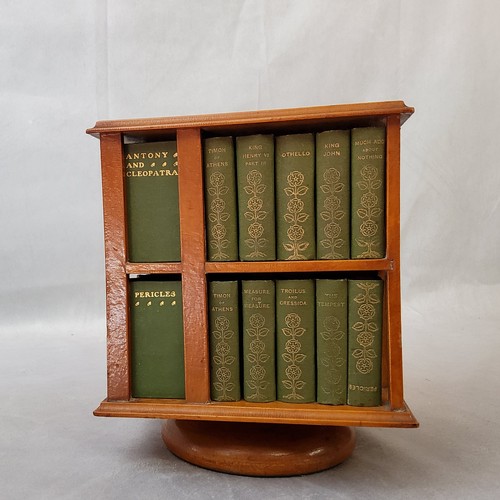 23 - A 1904 revolving miniature bookcase, containing miniature editions of the work of William Shakespear... 