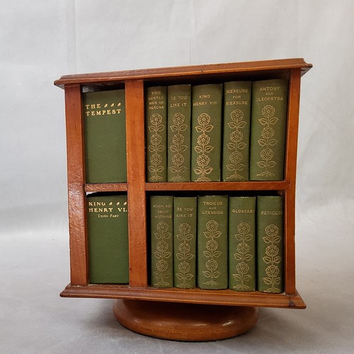 23 - A 1904 revolving miniature bookcase, containing miniature editions of the work of William Shakespear... 