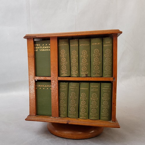 23 - A 1904 revolving miniature bookcase, containing miniature editions of the work of William Shakespear... 