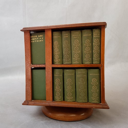 23 - A 1904 revolving miniature bookcase, containing miniature editions of the work of William Shakespear... 