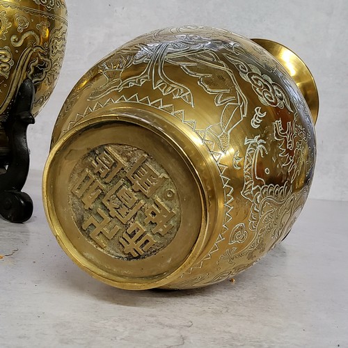 4 - A pair of Chinese bronze slender necked temple vases, cast in relief with a dragon, chased stylised ... 