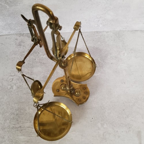10 - A late Victorian brass double beam weighing scales base holding 8 weights, (AF)39cm heigh x 30cm wid... 