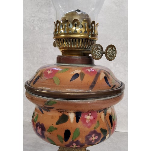 78 - An early 20th century oil lantern, Duplex burner with a tin glazed earthenware reservoir on a presse... 