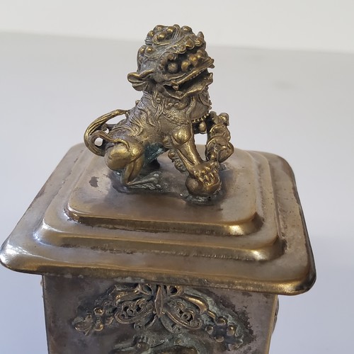 9 - An interesting Oriental canister surmounted with Dog of Foo handle, the rectangular body decorated i... 