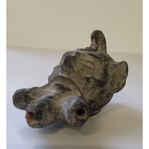 72 - A Roman military clay oil lamp depicting the mask of Pan with small pierced loop handle, pouring hol... 