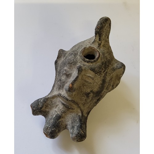 72 - A Roman military clay oil lamp depicting the mask of Pan with small pierced loop handle, pouring hol... 