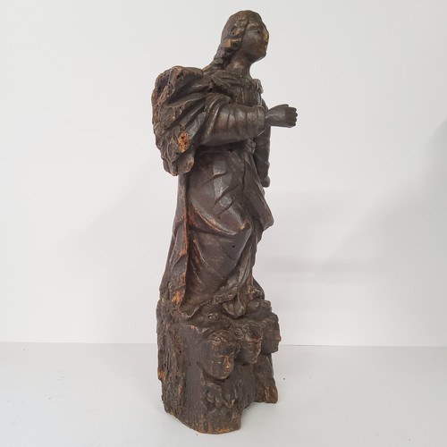 77 - An early 17th century Continental carved Saint figure raised on three cherubs to base. 40cm high