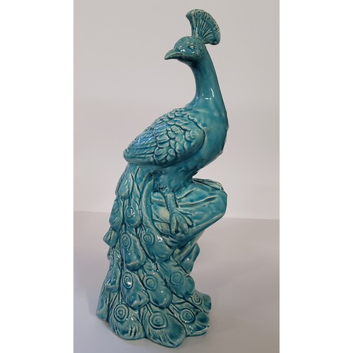 170 - A large turquoise glazed model of a peacock, impressed marks to base, standing 43cm high.