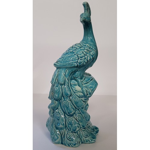 170 - A large turquoise glazed model of a peacock, impressed marks to base, standing 43cm high.