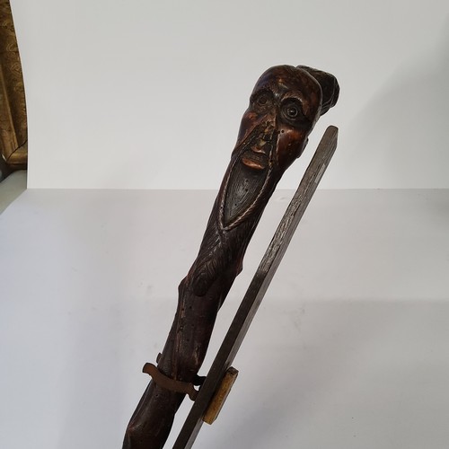 50 - Oriental - an early Japanese walking cane carved with a bearded elder and golden eagle mask pommel o... 