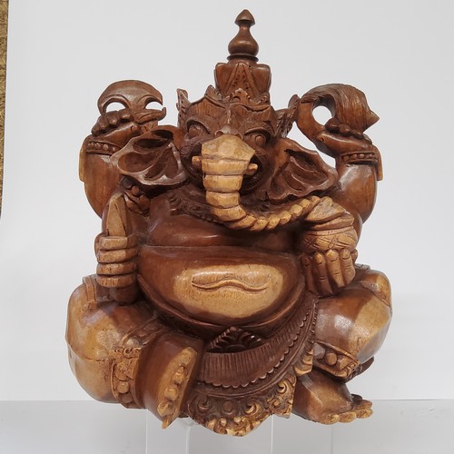 96 - A 20th century carved wood sculpture of the Hindu god Ganesha, India. 26cm high x 27cm wide