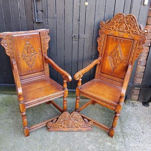 358 - A pair of country house Wainscot type hall chairs, profusely carved head rest with bold lozenge pane... 