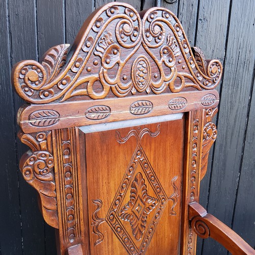 358 - A pair of country house Wainscot type hall chairs, profusely carved head rest with bold lozenge pane... 